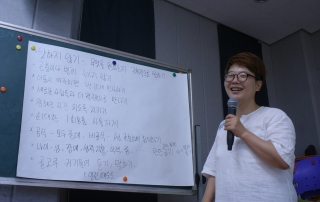 아침(글쓴이)가 칠판 앞에서 워크숍 진행을 하고 있다.