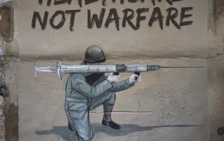 군인이 총대신 주사기를 들고 있는 그림. "Healthcare Not Warfare"라는 문구가 적혀있다.