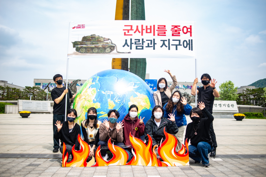 불타는 지구 모형 앞 단체 사진