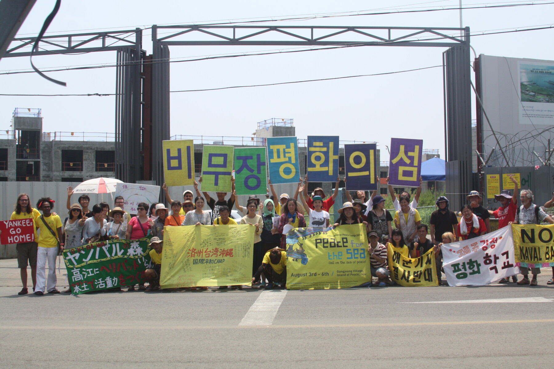 2014.8.7.제주도 강정마을 해군기지 공사장 앞에서 ‘비무장 평화의 섬’을 외치는 평화의 바다 캠프 참가자들 자료제공: 핫핑크돌핀스
