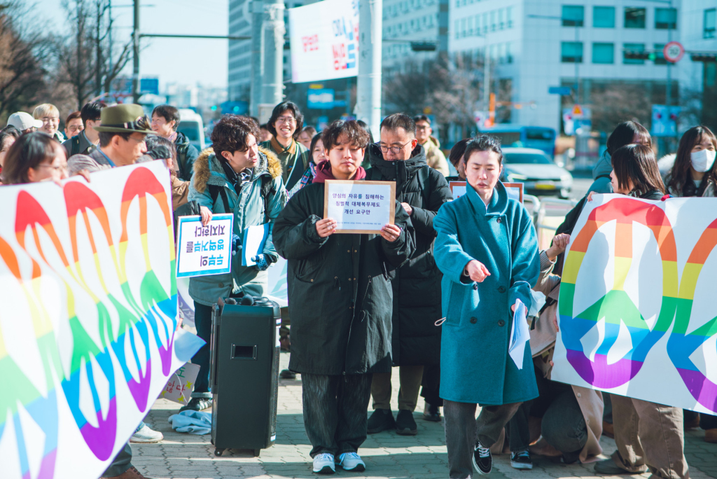 2026년 2월 23일 입영일에 진행한 두부의 병역거부 선언 기자회견 사진. 연대자들이 만들어준 평화의 길을 걷는 퍼포먼스를 하고 있다.